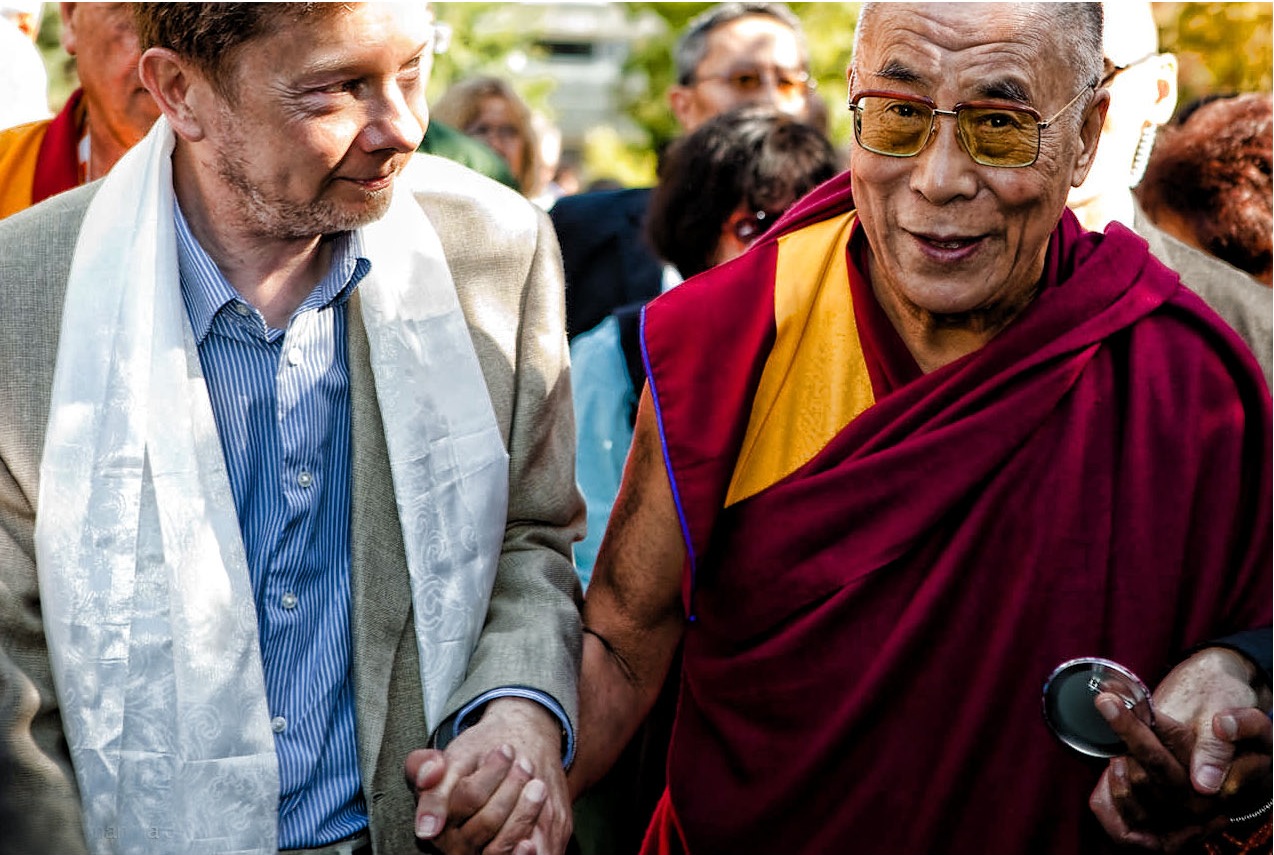 Eckhart Tolle and Dalai Lama in a mutually respectful embrace